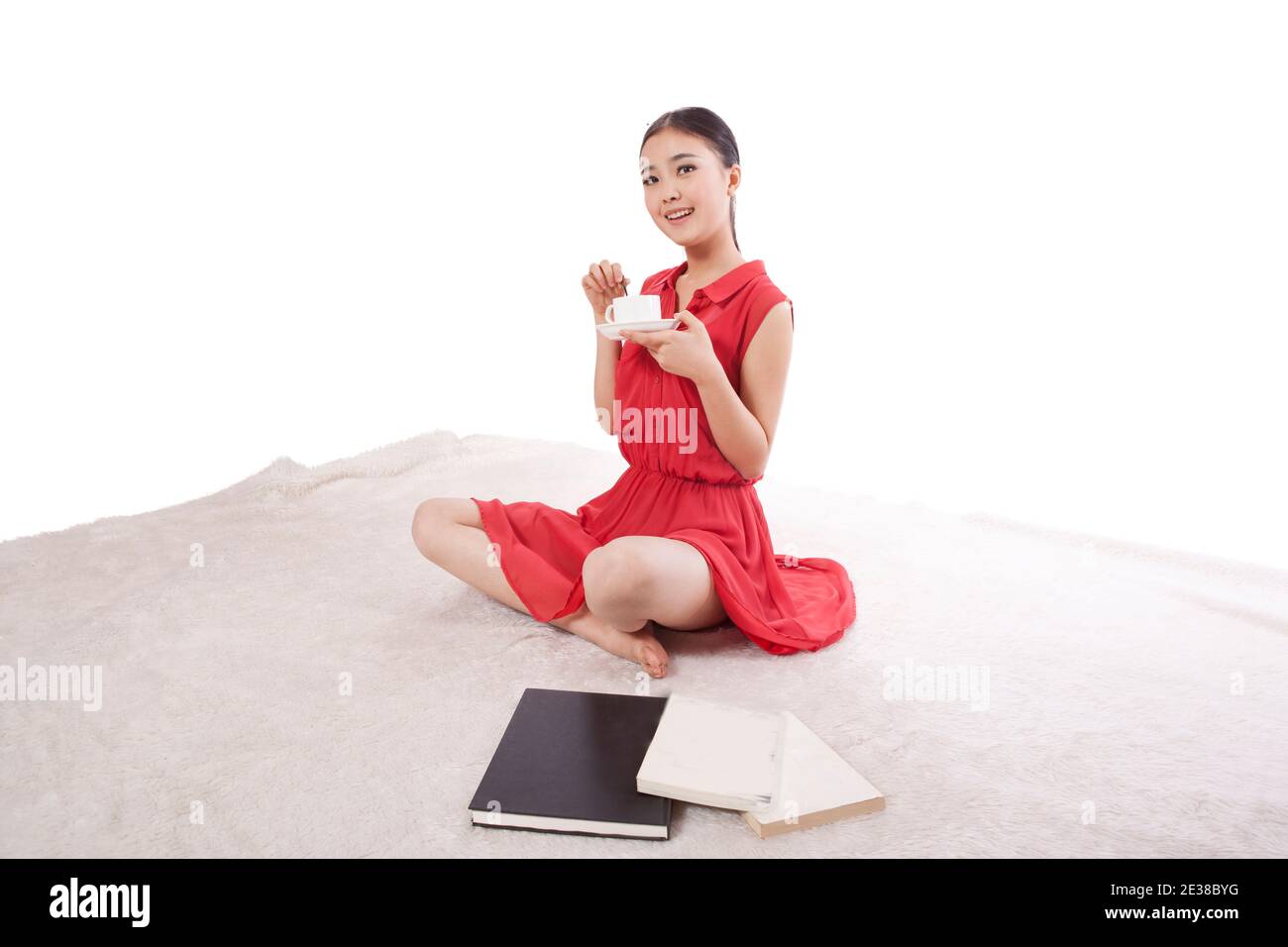 Giovane donna che ha una tazza di caffè, seduta foto di alta qualità Foto Stock