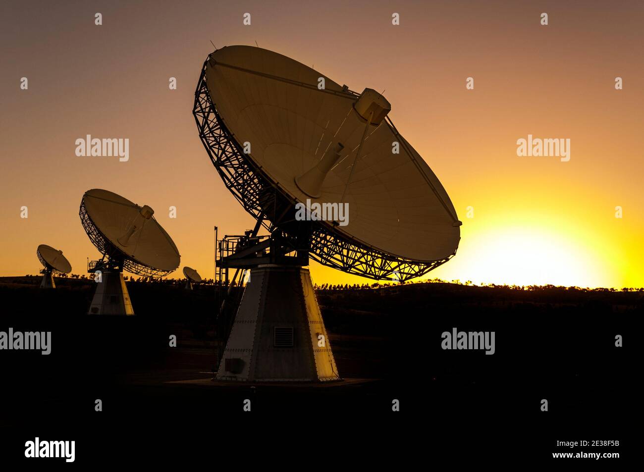 Grandi antenne per telecomunicazioni e tracciamento satellitare al tramonto, di fronte al cielo. Foto Stock
