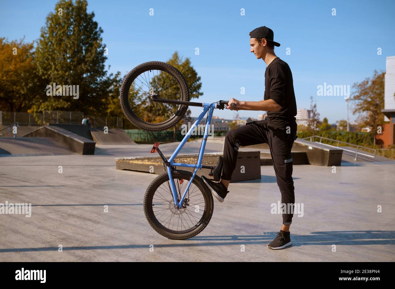 Biker maschile bmx facendo trucco, allenarsi in skatepark Foto Stock