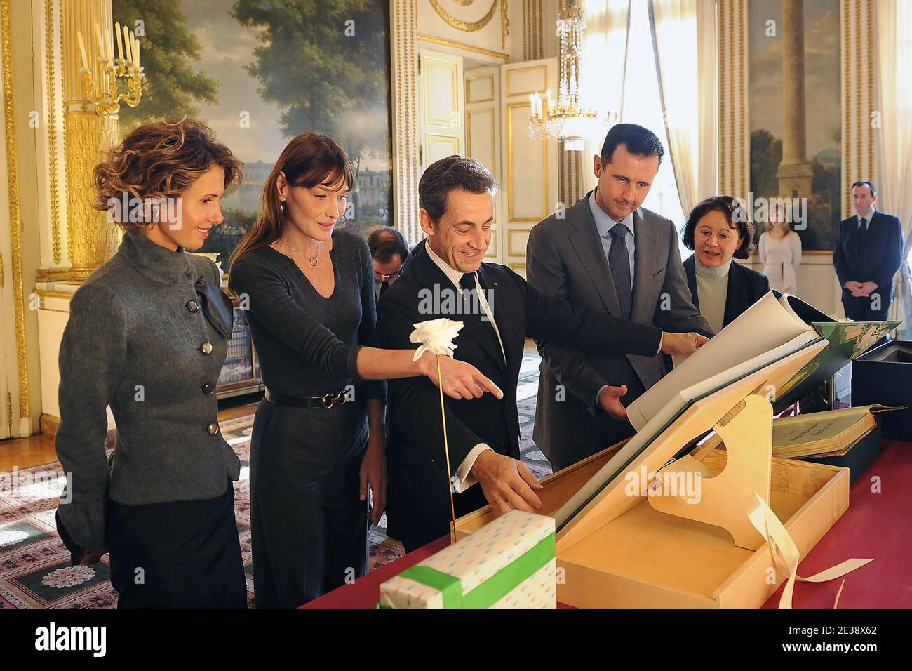 Il capo di stato siriano Bashar al-Assad e la moglie di Londra Asma al-Assad sembrano vivere in una surreale bolla psicologica, isolata dalla violenza grottesca che ha causato la vita a 8,000 siriani, Secondo una cache di circa 3,000 presunte e-mail e documenti ottenuti da attivisti siriani e pubblicati dal numero Guardian del 15 marzo 2012. File photo : il presidente francese Nicolas Sarkozy (C) e sua moglie Carla Bruni Sarkozy (2 da L) mostrano il presidente siriano Bashar El Assad (R) e sua moglie Asma (1 da L) regali, come il libro 'Terra vista dall'alto' al Palazzo Elysee a Parigi, Foto Stock
