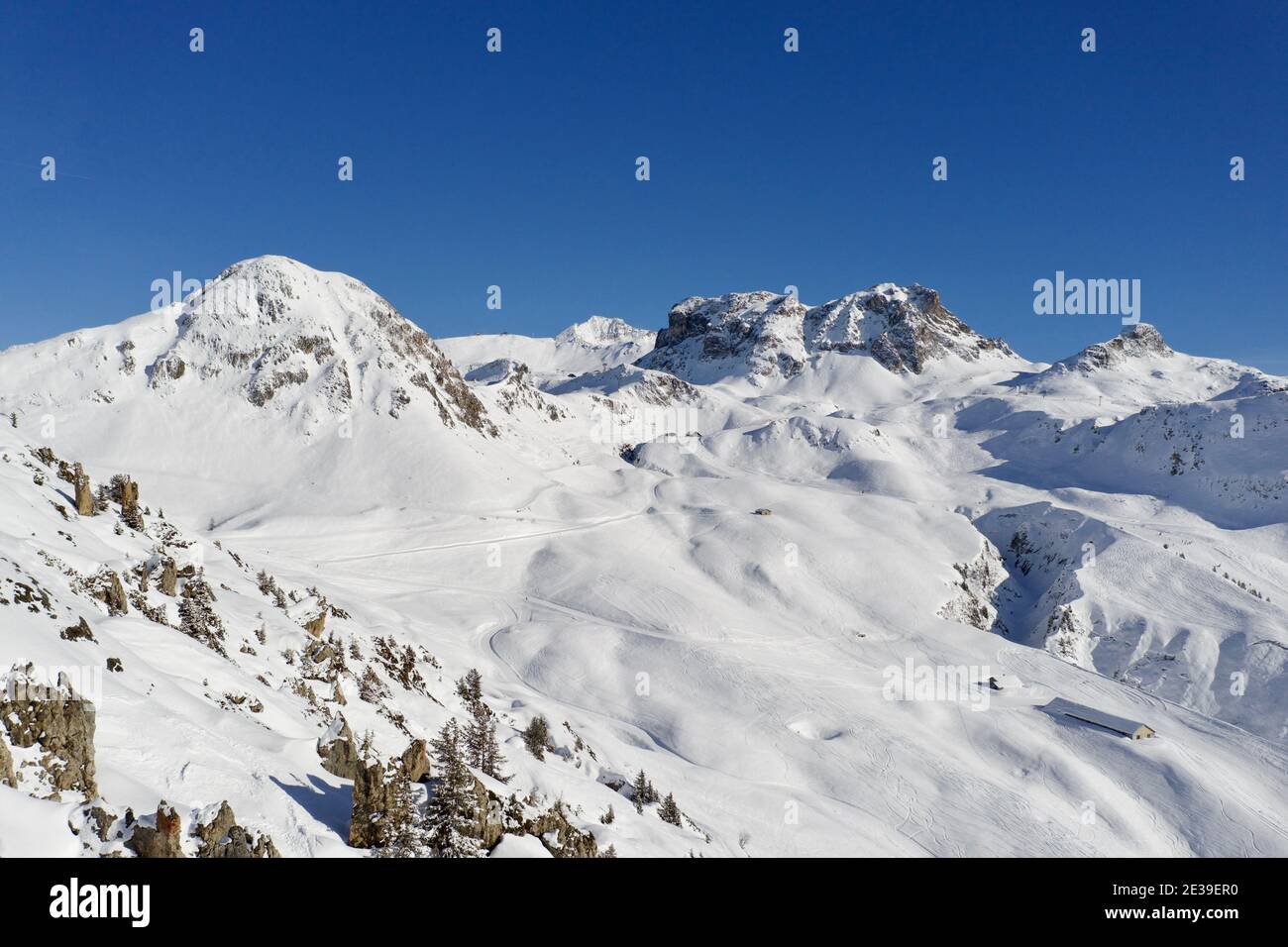 Vista sulle montagne innevate con cielo blu nella stazione sciistica Di la Plagne nelle Alpi francesi Foto Stock