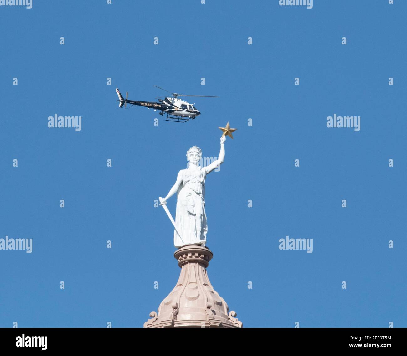 Austin, Texas, Stati Uniti . 17 gennaio 2021: Il Texas Department of Public Safety Helicopter sorvola la cupola del Campidoglio e la Dea della libertà, mentre i membri armati della milizia texana si sono riuniti al Campidoglio del Texas in uno spettacolo di forza prima dell'inaugurazione del presidente Joe Biden mercoledì. La maggior parte degli uomini che trasportano armi si è schierata a favore del loro diritto ai sensi del secondo emendamento, non necessariamente a sostegno del presidente uscente Donald Trump. Credit: Bob Daemmrich/Alamy Live News Foto Stock