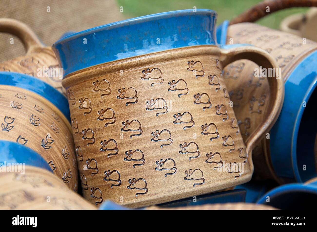 Tazze dipinte a mano di colore blu-marrone in argilla ceramica. Motivi animali - topi, cani, gatti, fiori. Artigianato tradizionale. Foto Stock