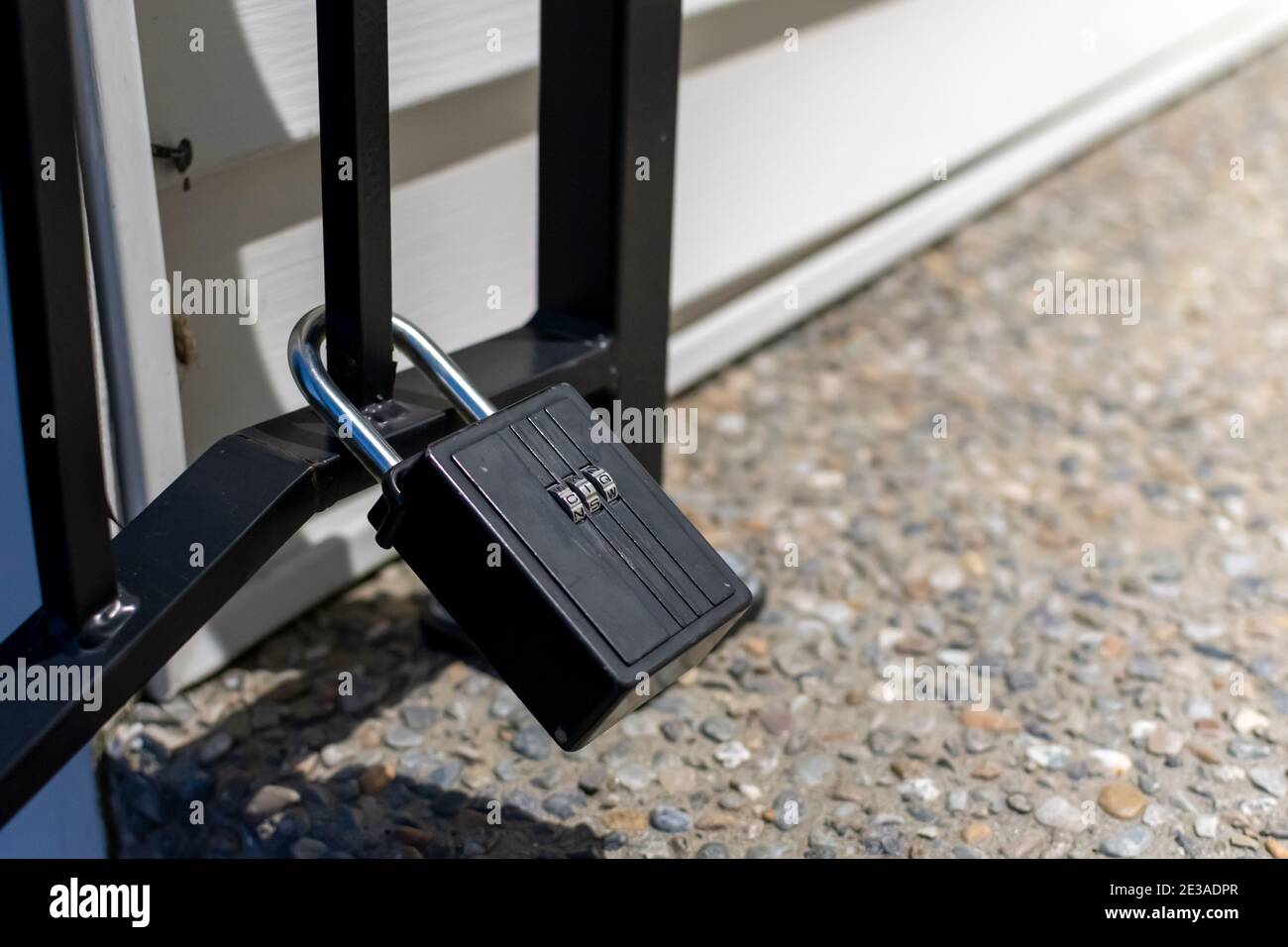 Una serratura a combinazione chiusa o un lucchetto fissato a un cancello di ferro in una casa. Foto Stock