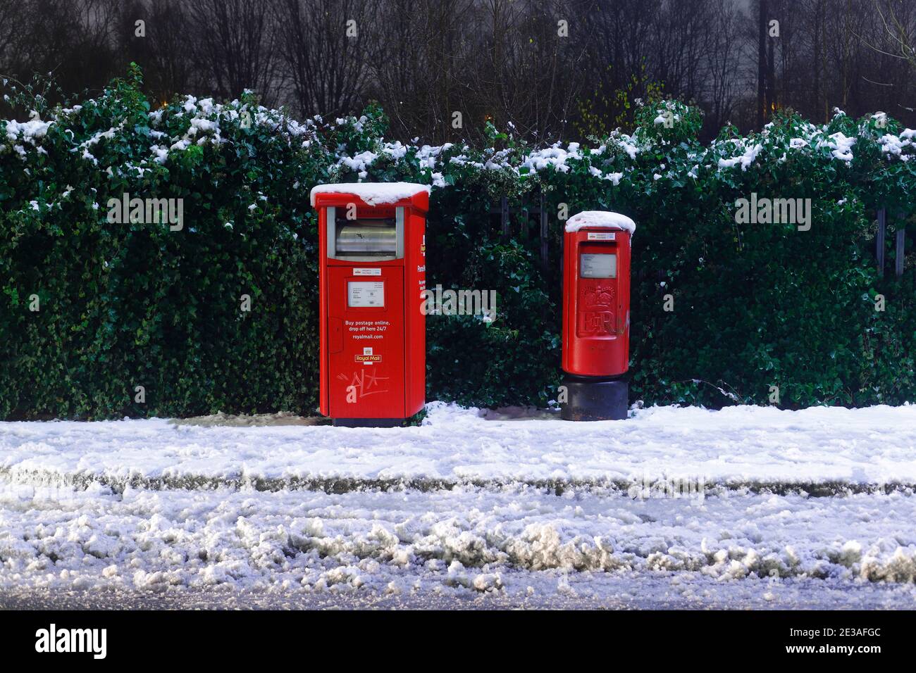 Una casella postale affrancata (a sinistra) e una casella postale reale standard coperta in Neve a Leeds Foto Stock