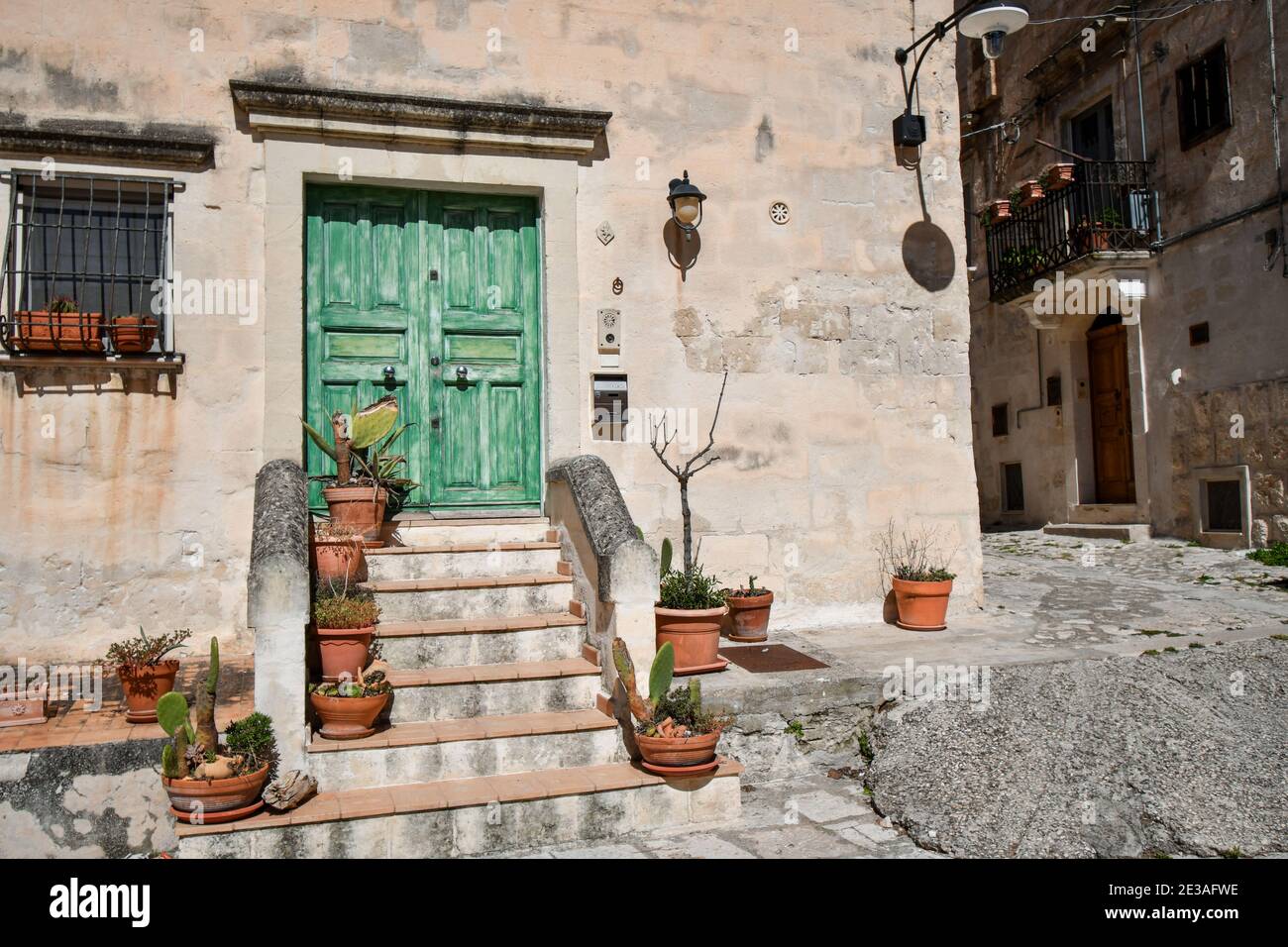 Una porta in legno, colorata e dipinta di verde, fuori da una casa nel centro storico di Matera, Italia. Foto Stock
