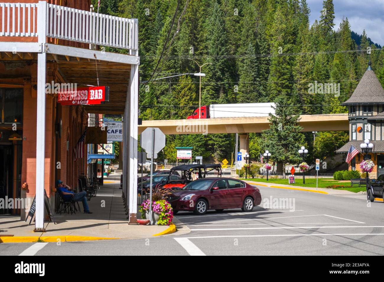 2020: Un uomo si rilassa sul marciapiede fuori dal bar del Wallace Hotel nella città mineraria della Silver Valley, a Wallace, Idaho, USA. Foto Stock