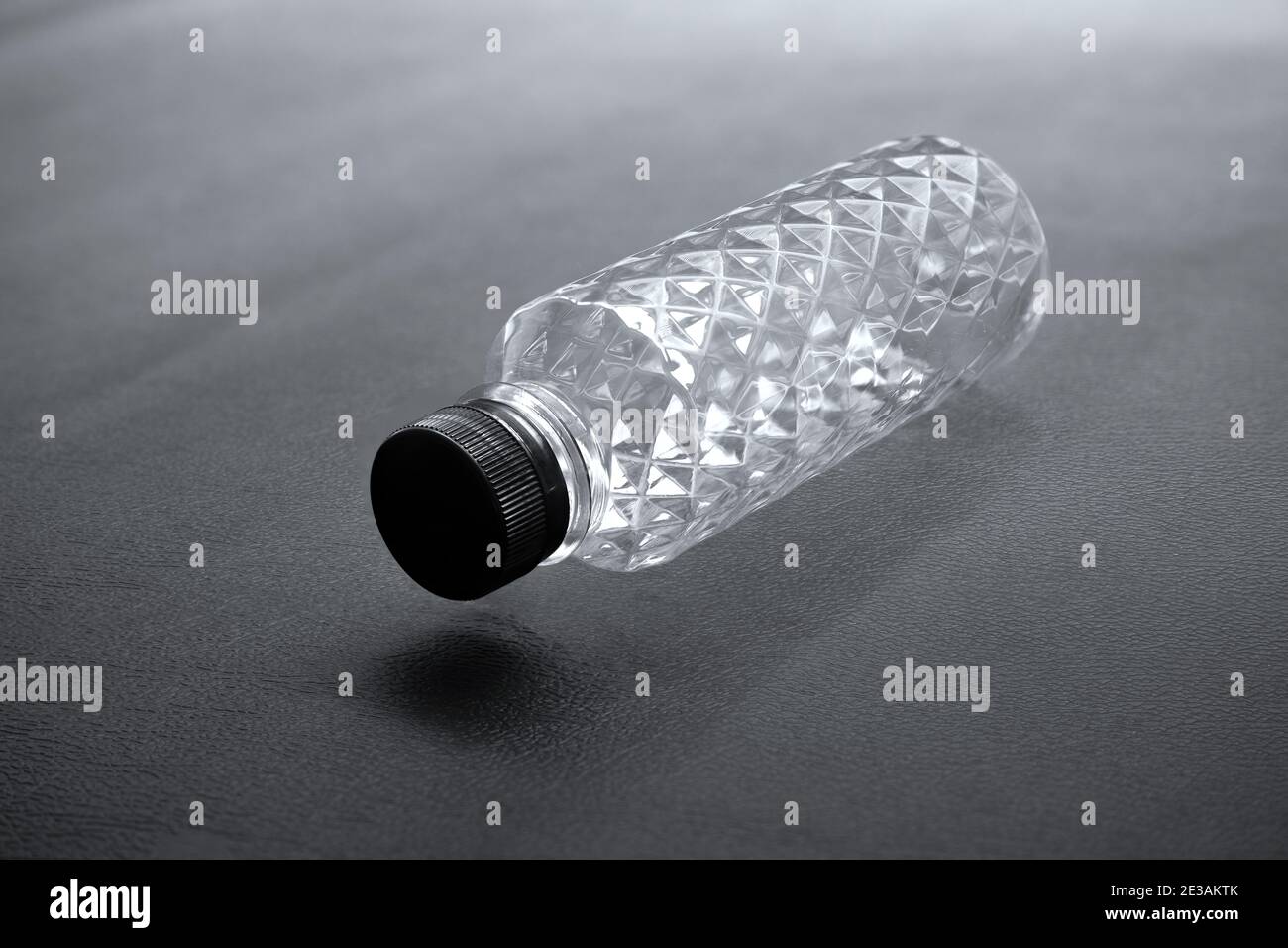 Bottiglie d'acqua di plastica di PET trasparenti e vuote sono state disposte alcune sfondi neri, il motivo di cristallo della bottiglia di glitter nel concetto di ricicla Foto Stock