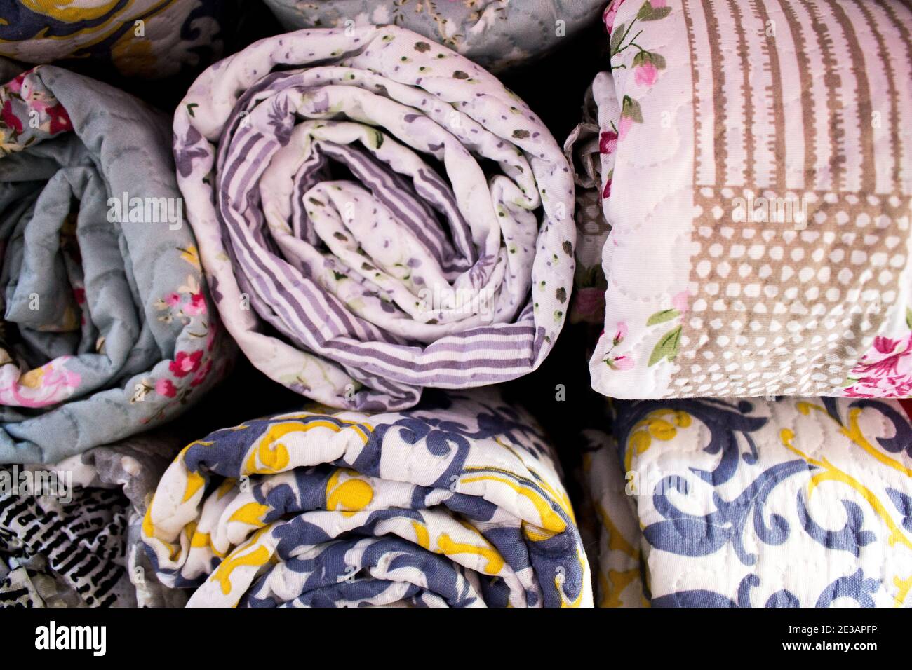 Primo piano di piumoni multipli rotolati e raggruppati l'uno vicino all'altro Foto Stock