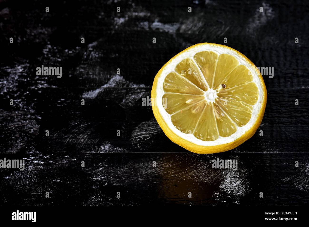 Limoni freschi maturi su fondo di pietra scuro/ limone mezzo maturo su fondo nero. Scorza di limone. Vitamina C. Foto Stock