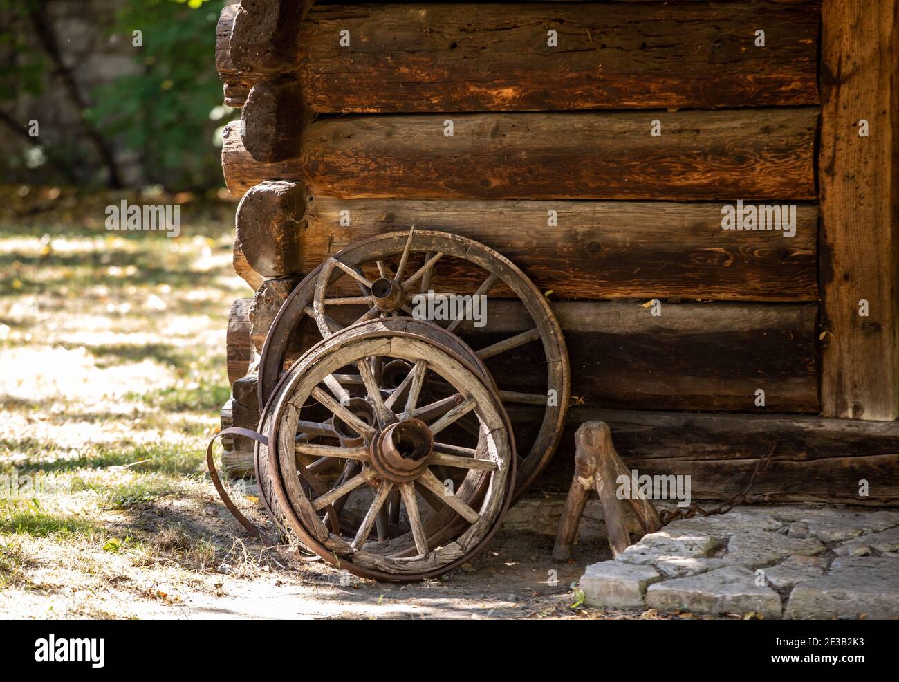 Ruote di legno da un carrello antico in piedi di fronte il muro di un  cottage di campagna in legno Foto stock - Alamy