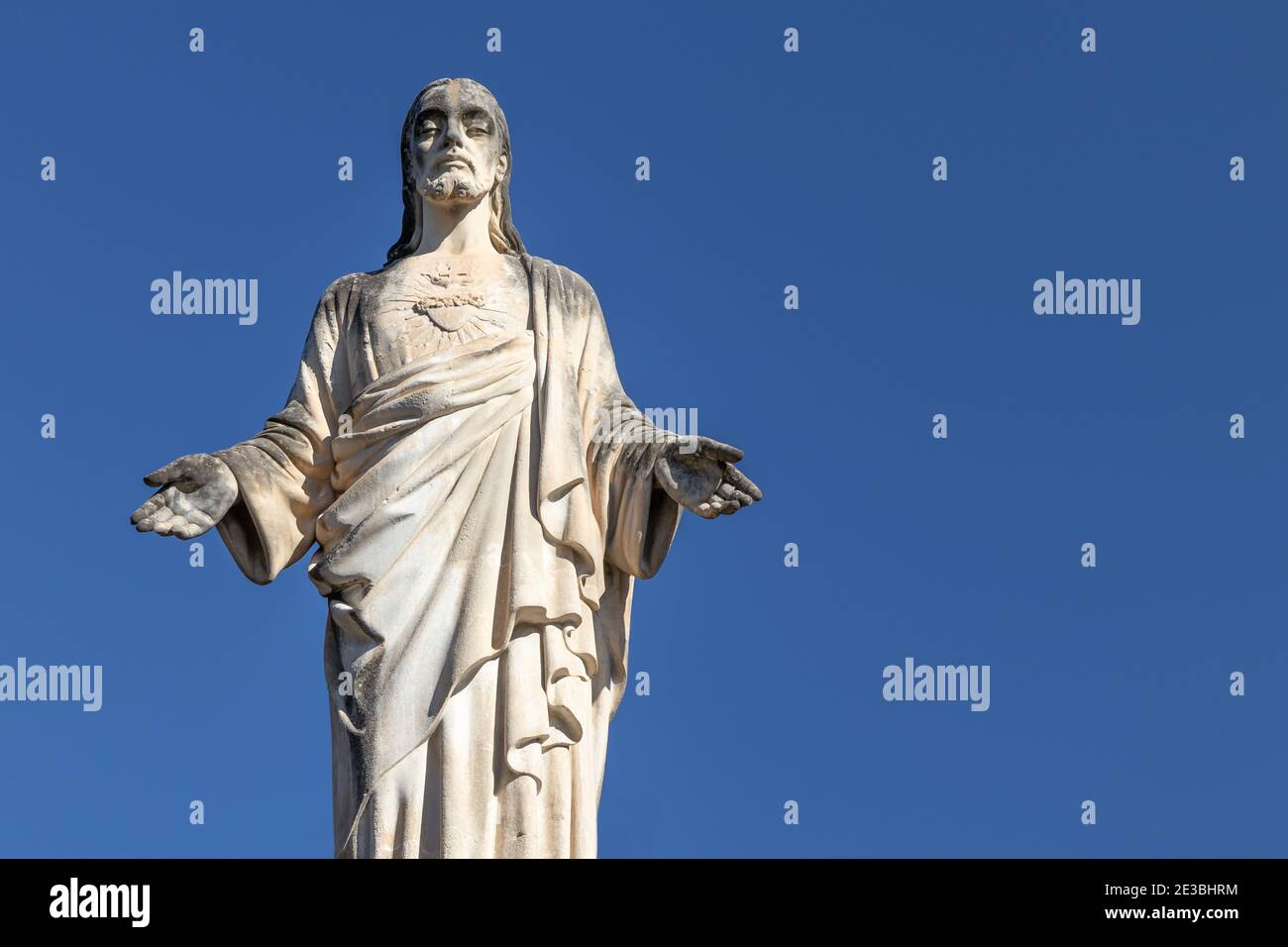 Cristo (Gesù Cristo) antica statua di Sant Quirze del Valles, Spagna. Sfondo blu chiaro, spazio di copia Foto Stock