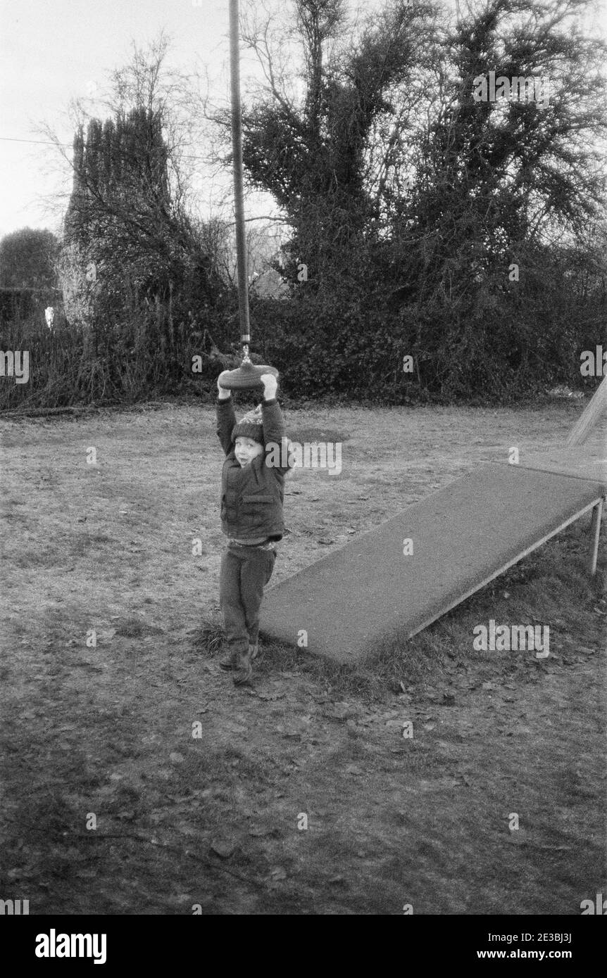 Ragazzo di quattro anni che gioca su una zip-wire a Playground, Medstead, Hampshire, Inghilterra, Regno Unito. Foto Stock