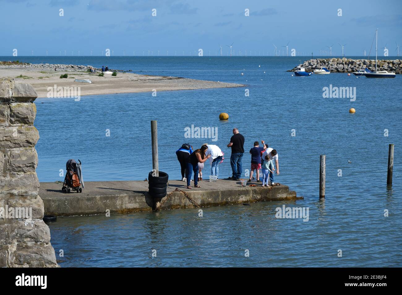 Una famiglia di turisti pesca al largo di un molo a Rhos-on-Sea, Galles del Nord Foto Stock