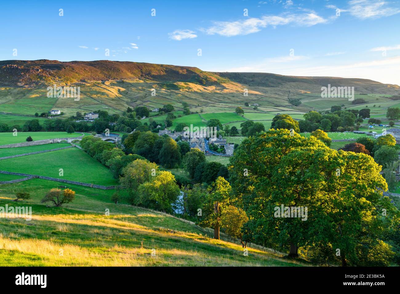 Scenic Sunny Burnsall villaggio nella valle del fiume Wharfe (pendii collinari, alta brughiera, campi verdi, pascoli, cielo blu) - Yorkshire Dales, Inghilterra, UK Foto Stock