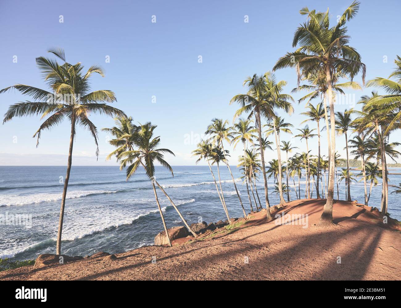 Spiaggia tropicale con palme da cocco al tramonto, immagine colorata. Foto Stock