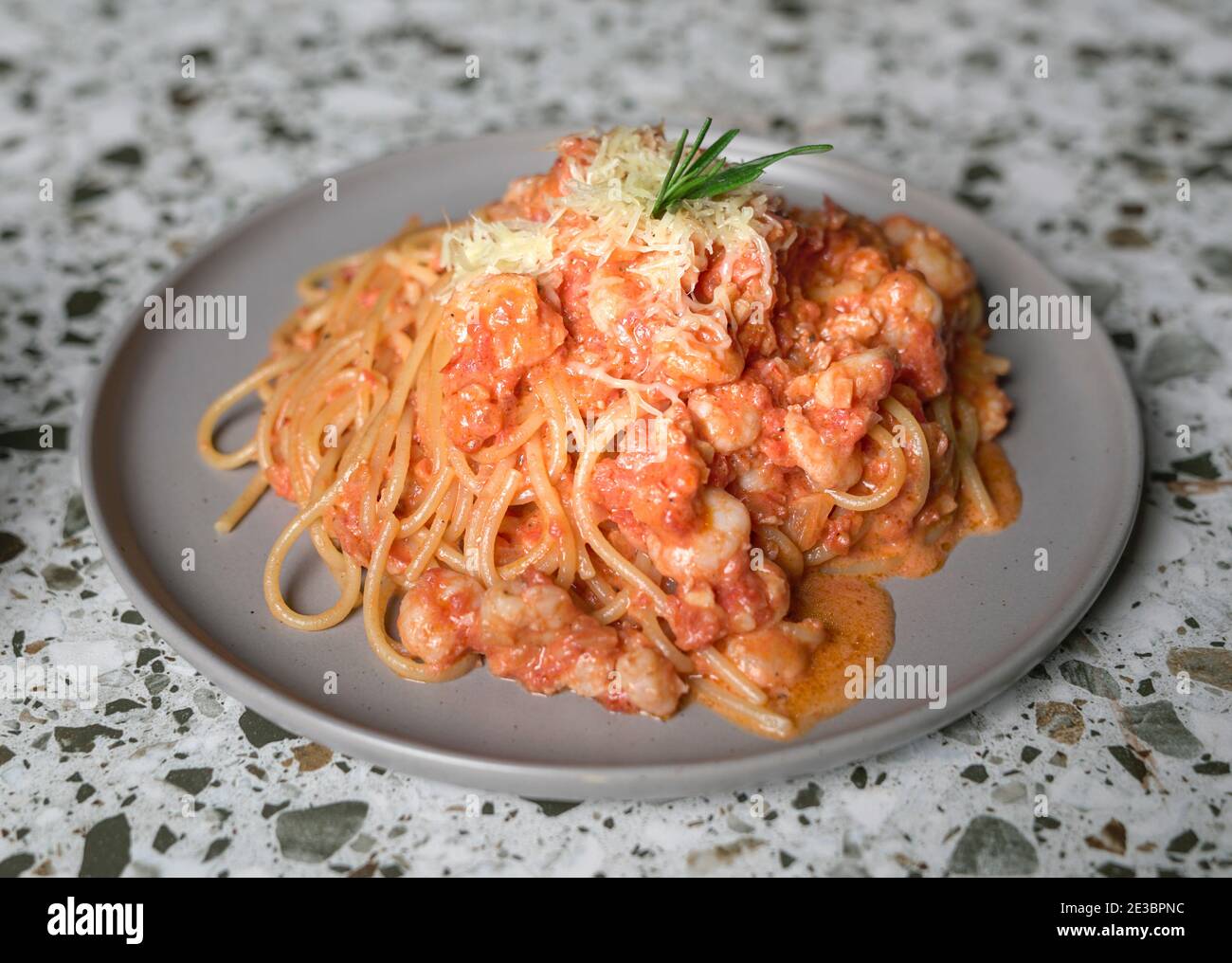 Deliziosi spaghetti di pasta con gamberi, salsa di pomodoro, formaggio sul piatto. Isolato. Foto Stock