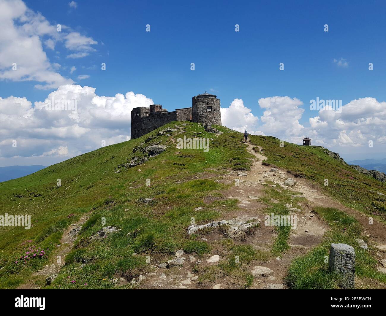 Vecchio osservatorio sul monte PIP Ivan. Cielo blu sullo sfondo. In alcuni luoghi, sul versante verde, sono visibili i fiori rosa di Chervona Ruta. Foto Stock