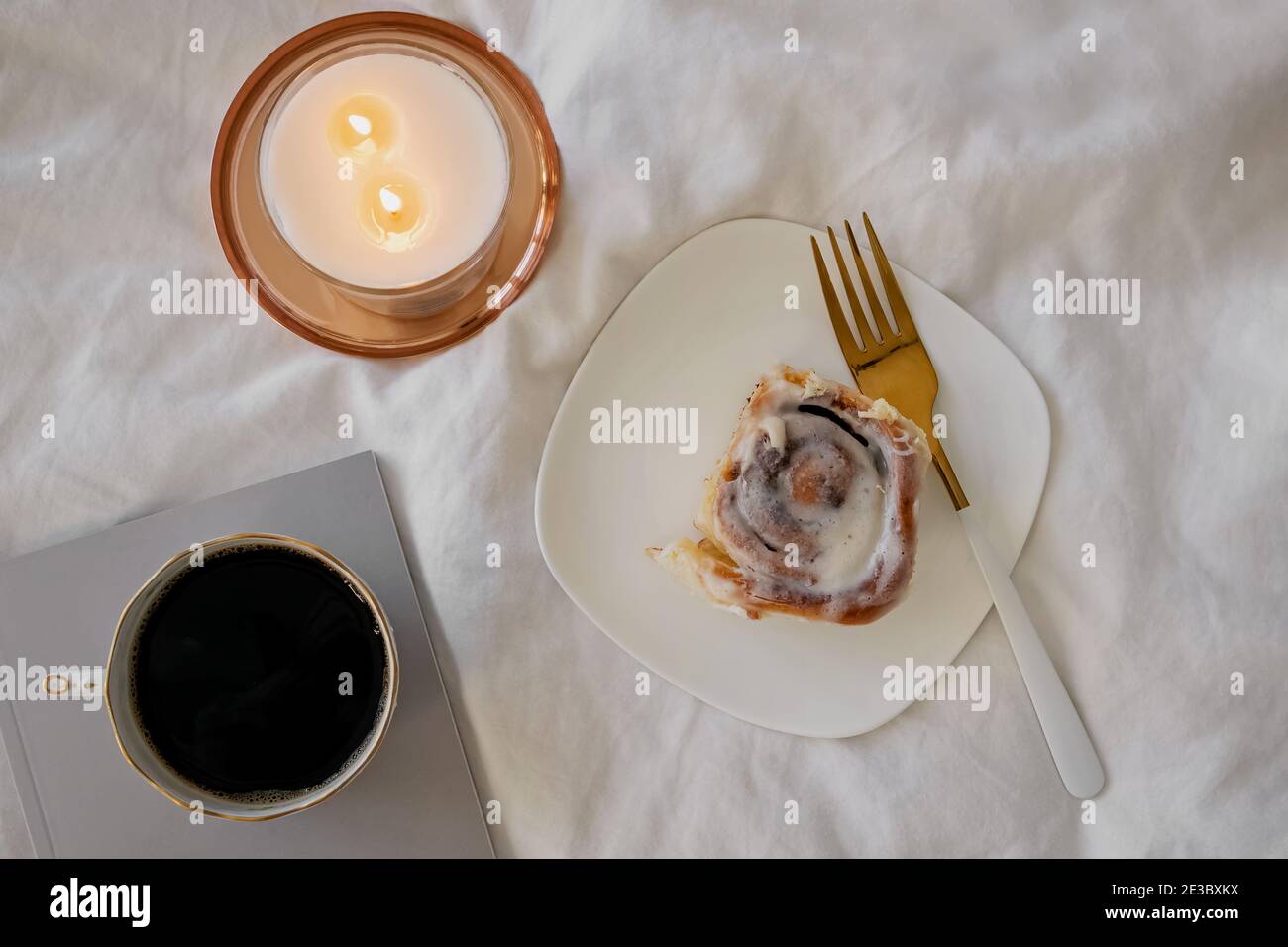 Composizione stile di vita con panna alla cannella, caffè e candela bruciante Foto Stock