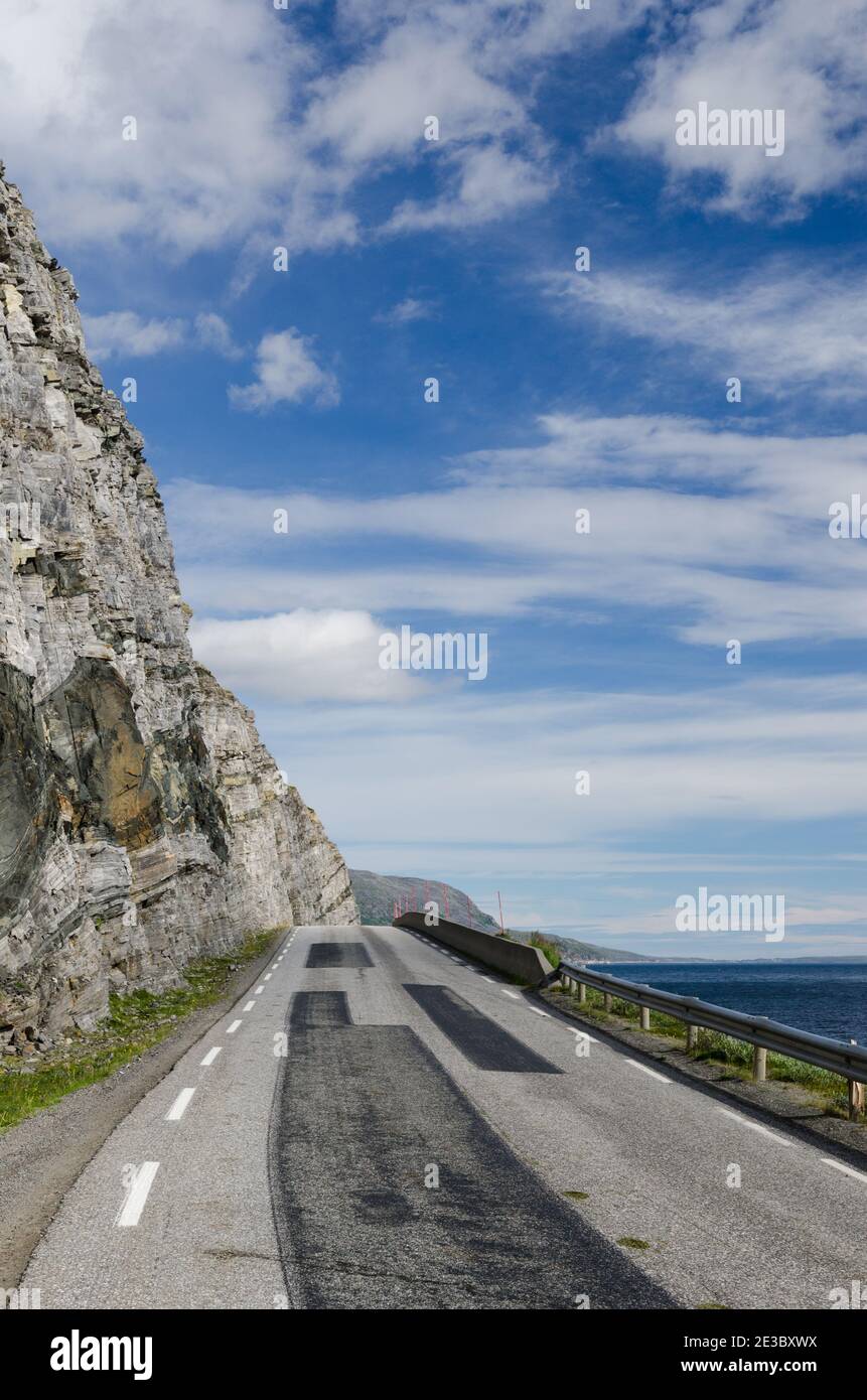 Strada asfaltata con zone fresche vicino alla baia di Skarvbergvika, Norvegia Foto Stock