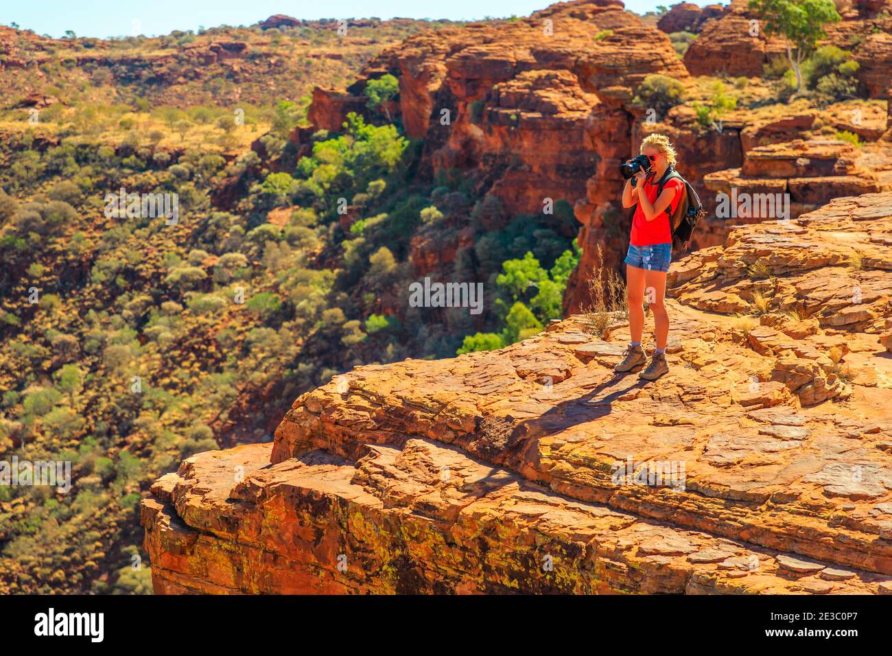 Fotografo di viaggio che scatta foto della scogliera di arenaria nel Kings Canyon Watarrka National Park. Concetto di scoperta di viaggio dell'Australia centrale. Donna con Foto Stock