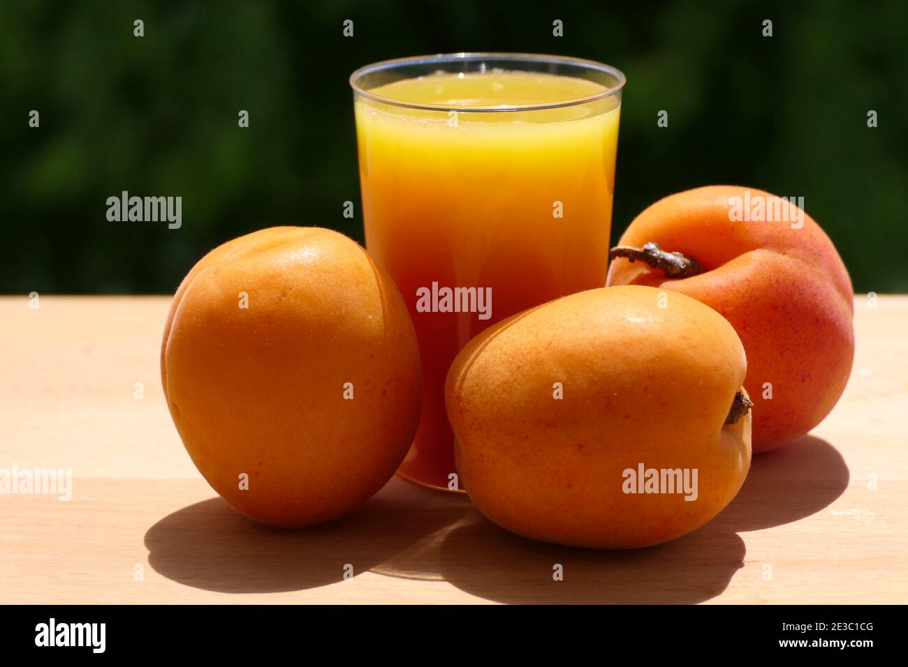 Albicocche e succo di albicocca appena spremuto in tazza di luce naturale Foto Stock