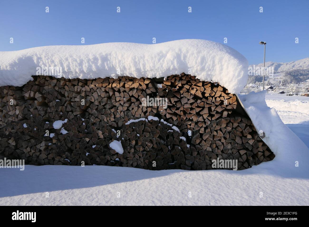 Un palo di legna da ardere accatastato appena innevato dentro Foto Stock