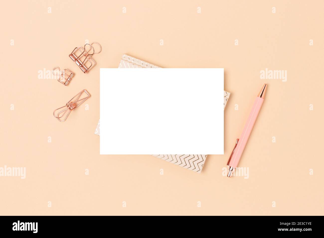 Cartoncino di carta vuoto e layout di cancelleria su sfondo beige. Area di lavoro minimalistica. Foto Stock