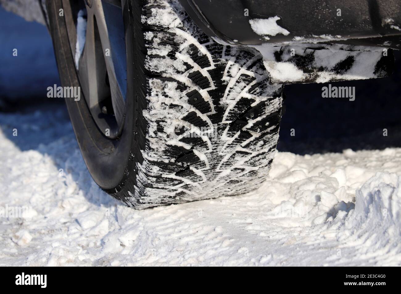 Ruota coperta di neve su strada. Pneumatici invernali, guida a basse temperature e ghiaccio Foto Stock