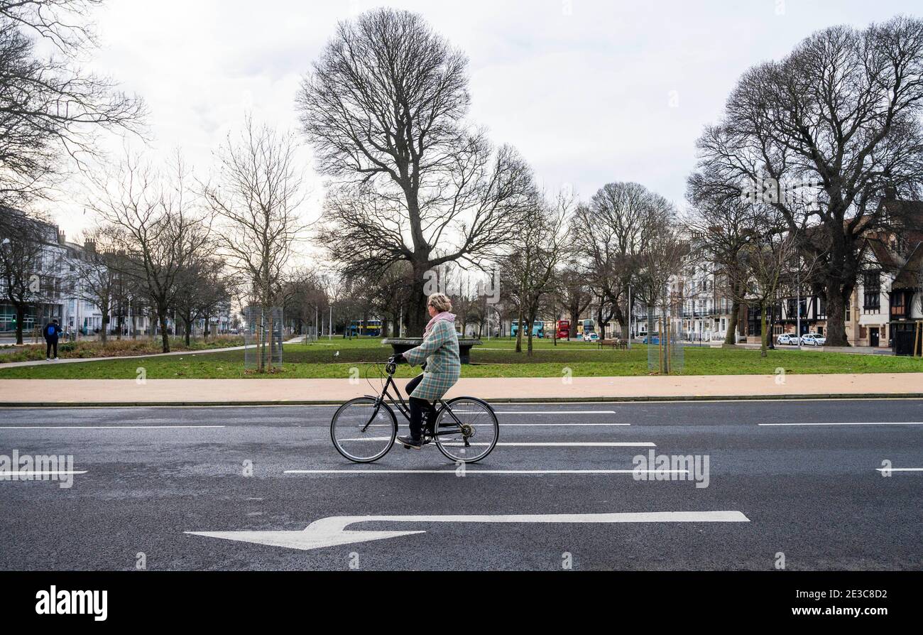 Brighton UK 18 gennaio 2021 - UNA donna attraversa il centro di Brighton durante le restrizioni di blocco in Inghilterra . Il terzo lunedì in gennaio è conosciuto come lunedì blu perché è apparentemente il giorno più deprimente dell'anno: Credit Simon Dack / Alamy Live News Foto Stock