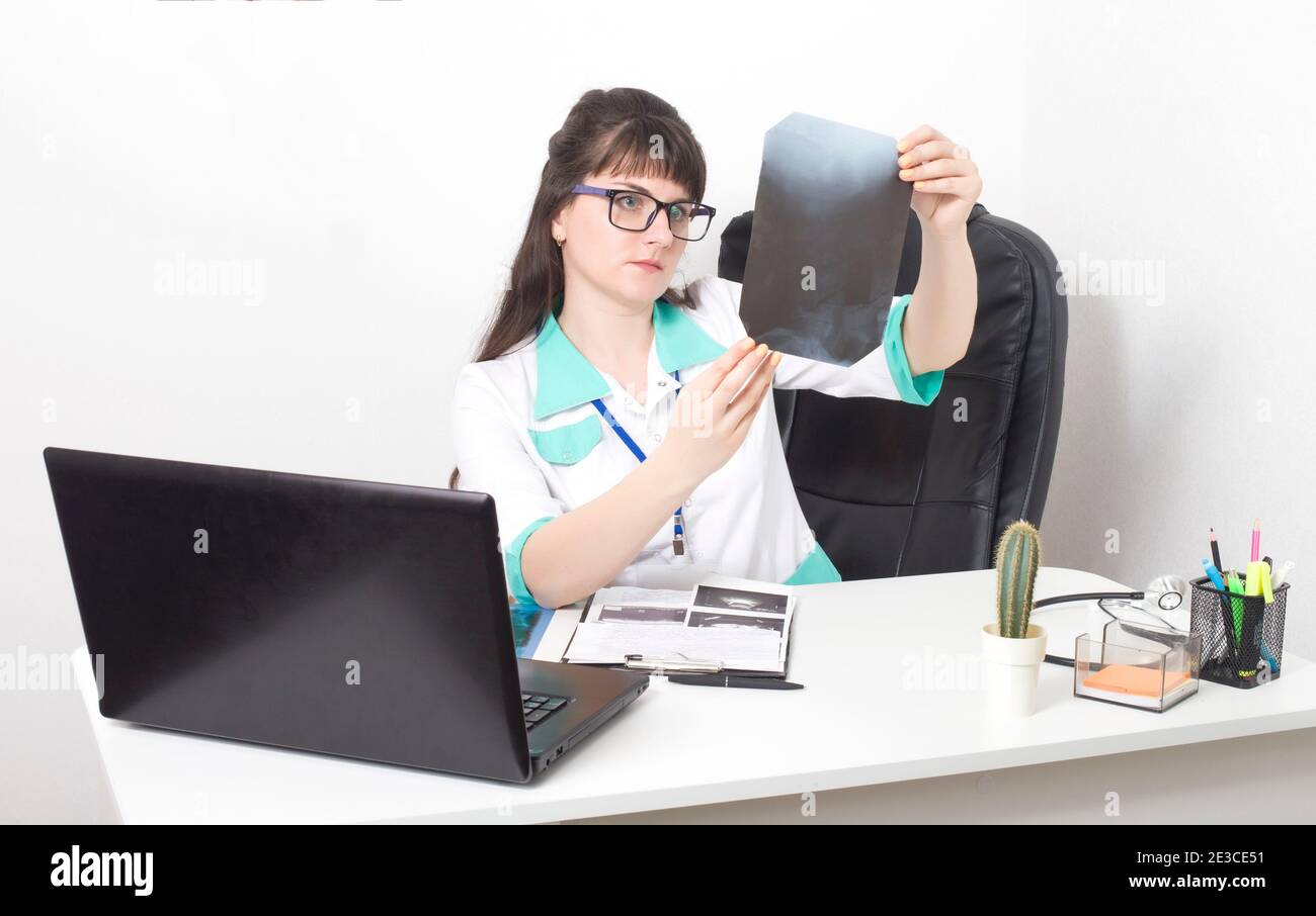 Il medico andrologo esamina un'immagine radiografica della colonna vertebrale. Trattamento dell'artrite e della gotta, sfondo. Clinica medica, osteoporosi Foto Stock