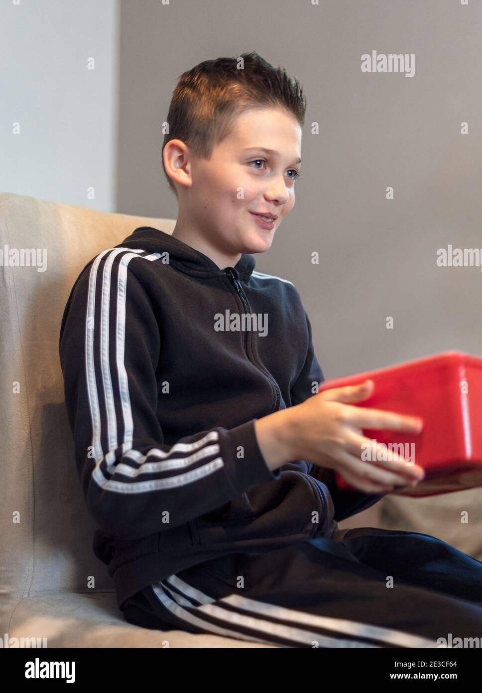 Bel ragazzo di 13 anni sorridente felice che riceve un presente avvolto Foto Stock