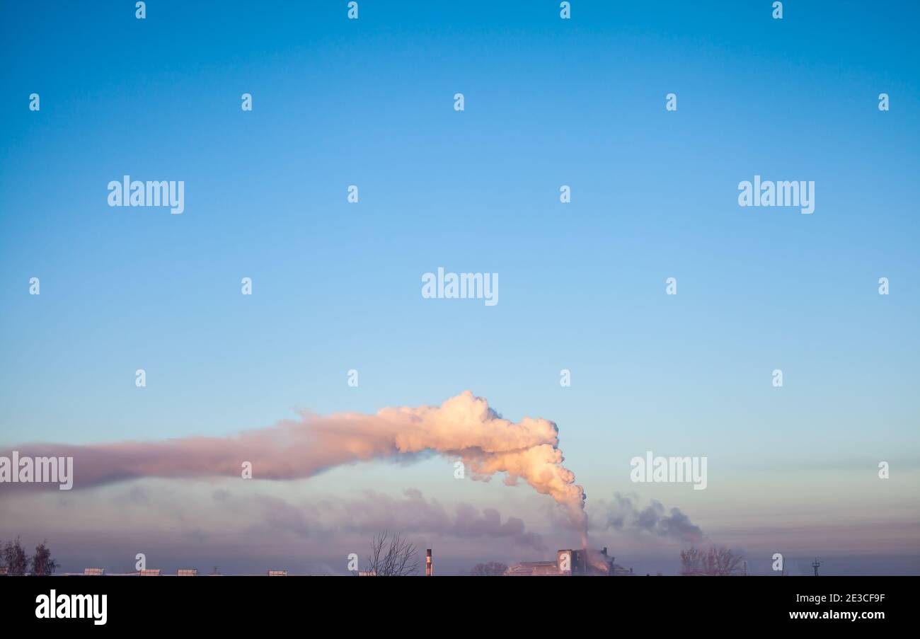 Fumo bianco spesso dal camino del locale caldaia. Fumo contro il cielo blu. Inquinamento atmosferico. Riscaldamento della città. Zona industriale. Foto Stock