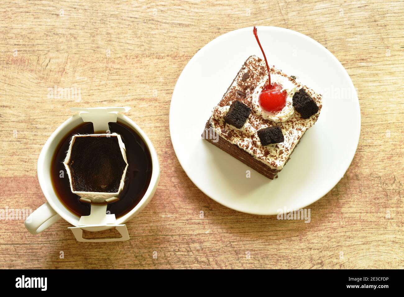 torta nera più piccante con crema di ciliegia e caffè caldo filtro antigoccia nel bicchiere Foto Stock