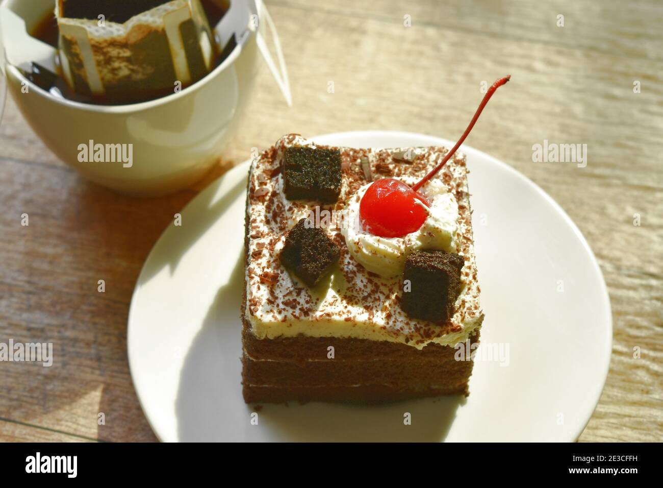 torta nera più piccante con crema di ciliegia e caffè caldo filtro antigoccia nel bicchiere Foto Stock