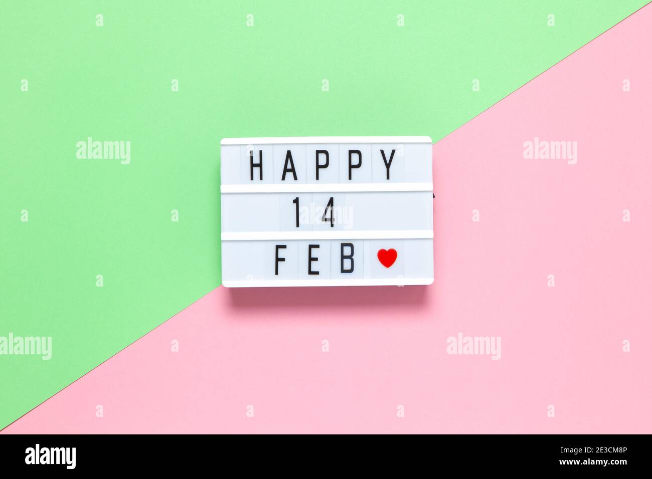 Lavagna luminosa con iscrizione Happy 14 feb e piccolo cuore rosso su sfondo rosa pastello e verde, spazio copia, piatto. 14 febbraio, San Valentino d Foto Stock