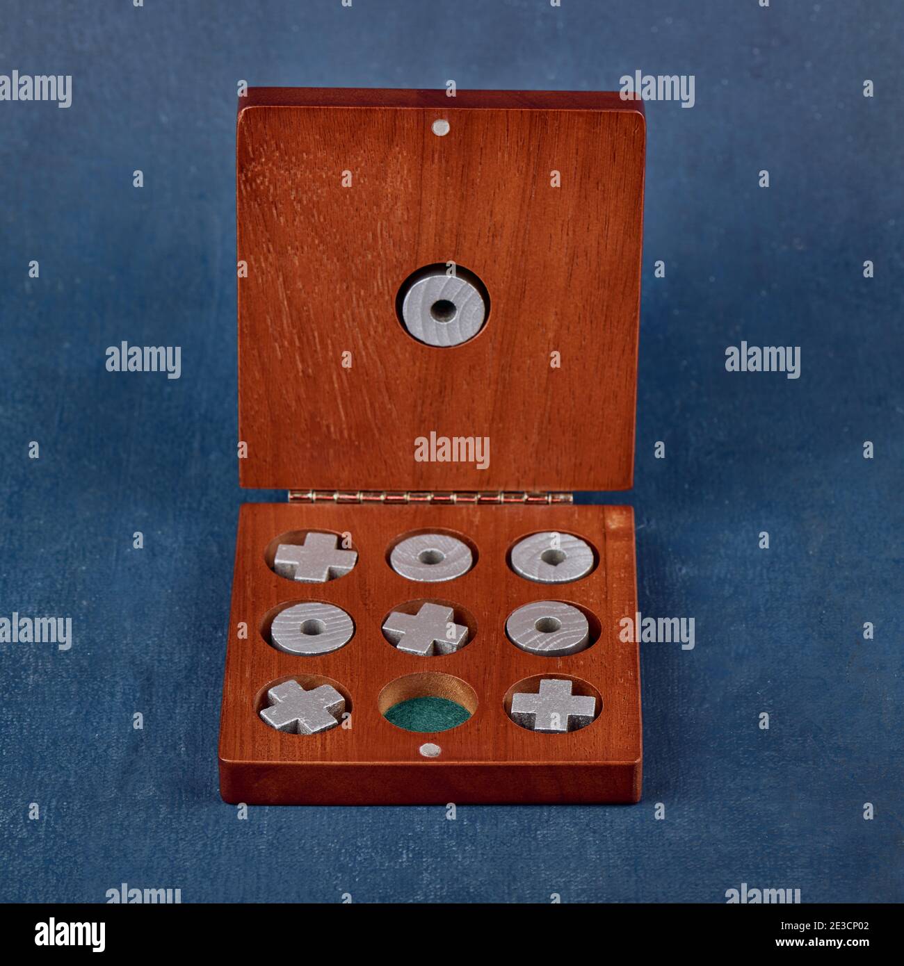 Gioco di Tic TAC Toe in una scatola di legno su uno sfondo blu, profondità di nitidezza poco profonda Foto Stock