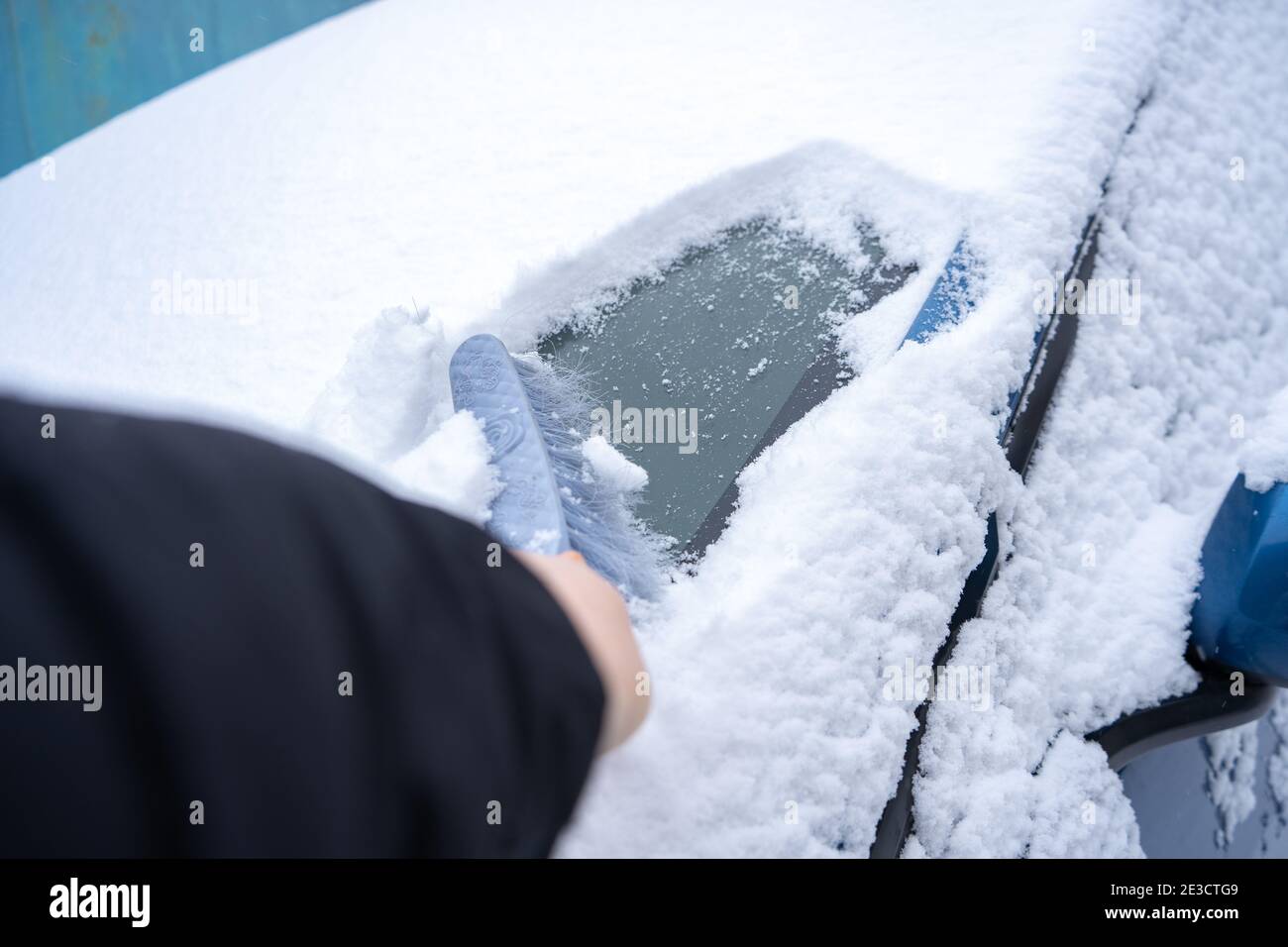 Rimuovere la neve dal parabrezza della vettura con la spazzola per auto Foto Stock