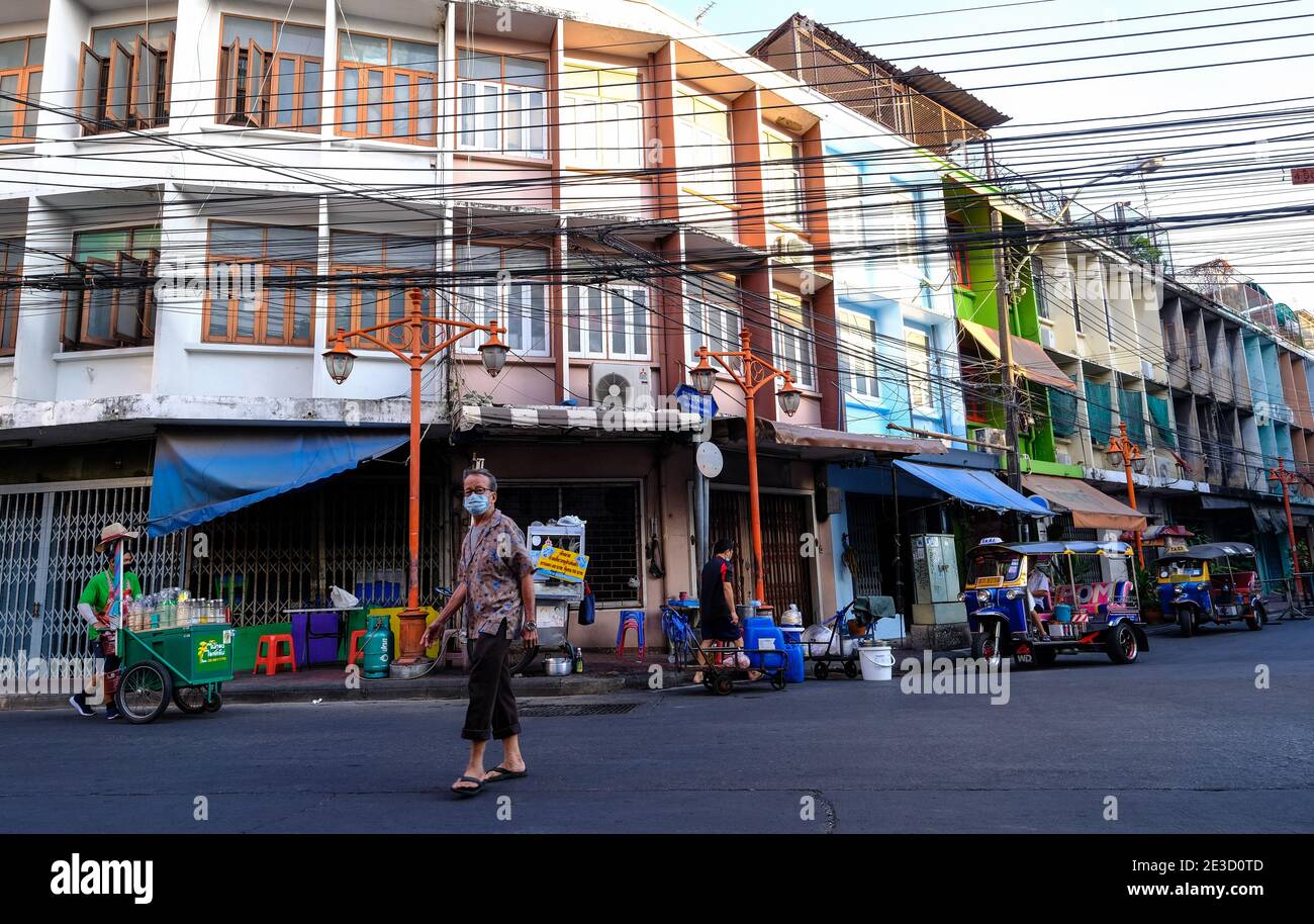 Un uomo attraversa una strada a Chinatown, Bangkok, Thailandia Foto Stock