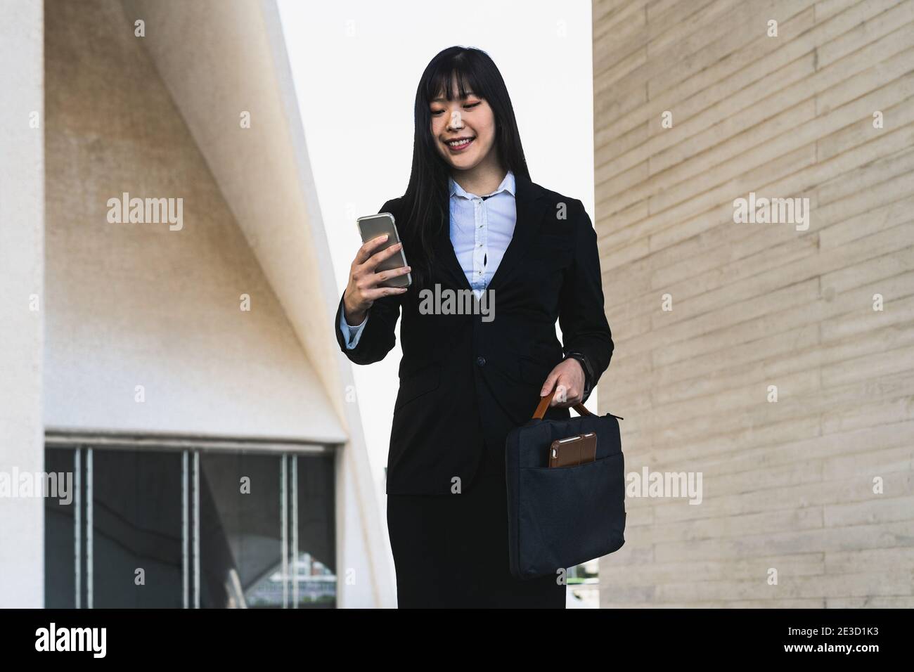 Donna d'affari asiatica che usa lo smartphone mobile fuori dall'ufficio - Concetto di imprenditorialità Foto Stock