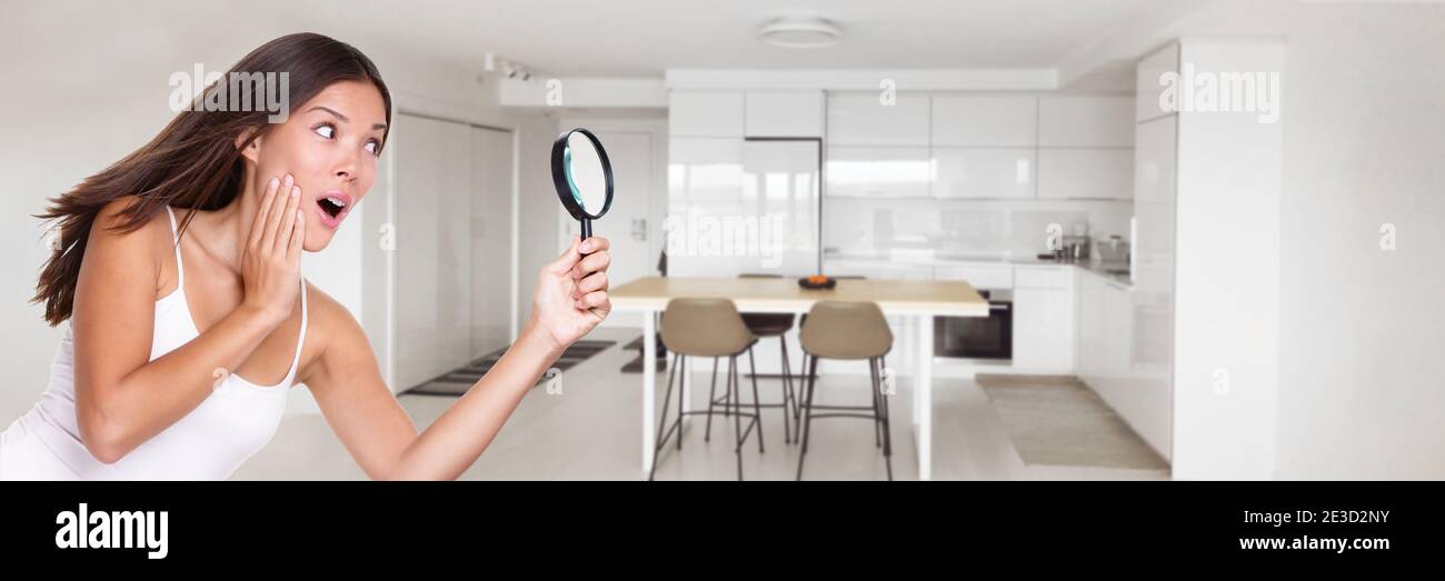 Ispezione domestica donna sorpresa divertente ricerca attraverso lente di ingrandimento guardando in cucina per i difetti nascosti compratore domestico di bene immobile che ispeziona per Foto Stock