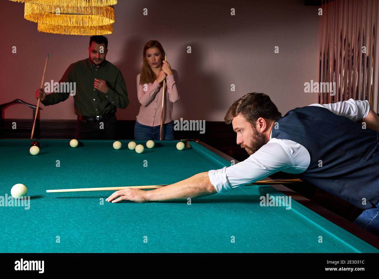 l'uomo sta giocando a snooker, sta puntando a sparare la palla snooker. bel  ragazzo tiene le mani sul tavolo snooker. biliardo Foto stock - Alamy