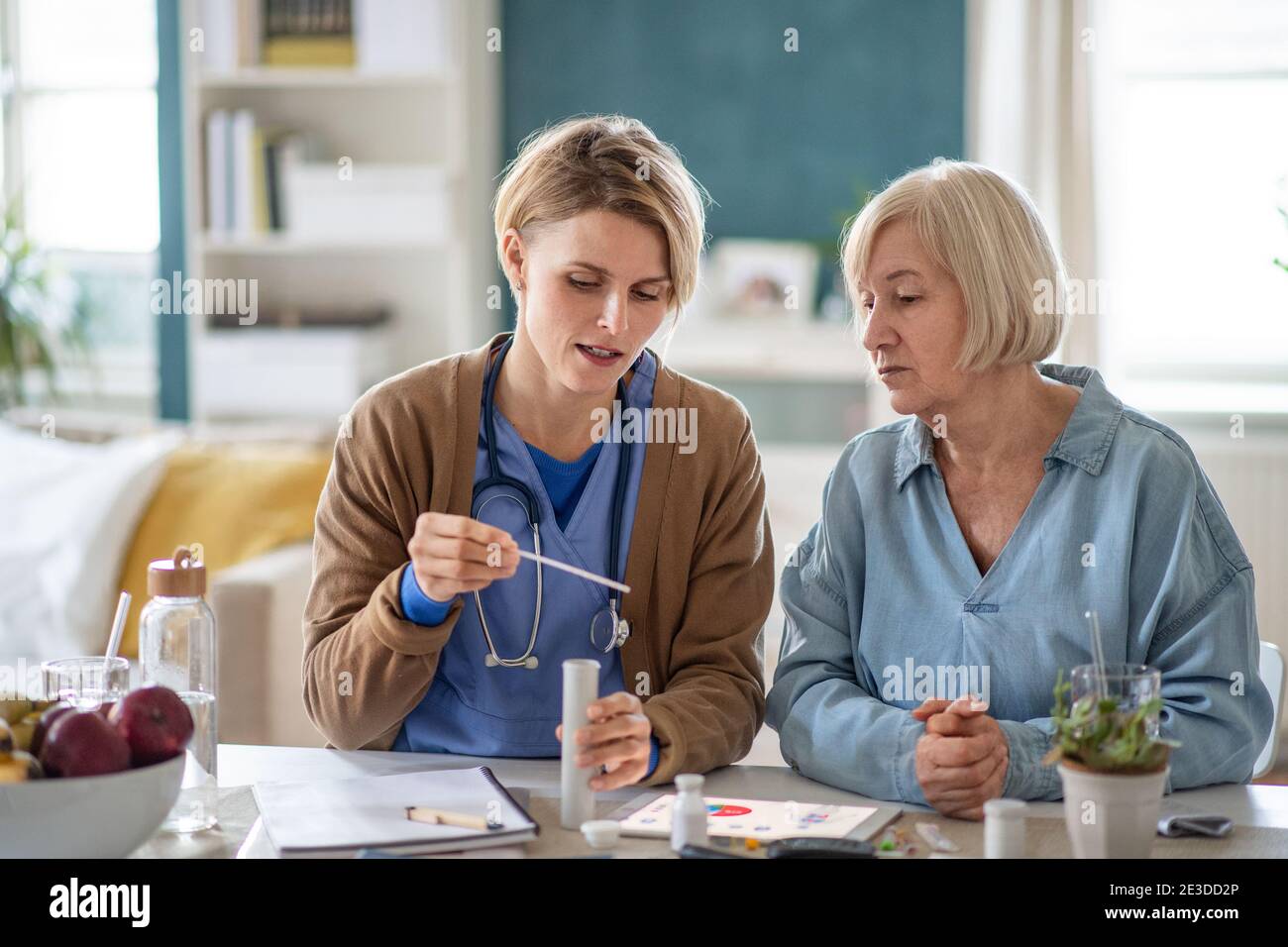 Operatore sanitario o operatore sanitario con paziente anziano, spiegando come usare la carta di tornasole. Foto Stock