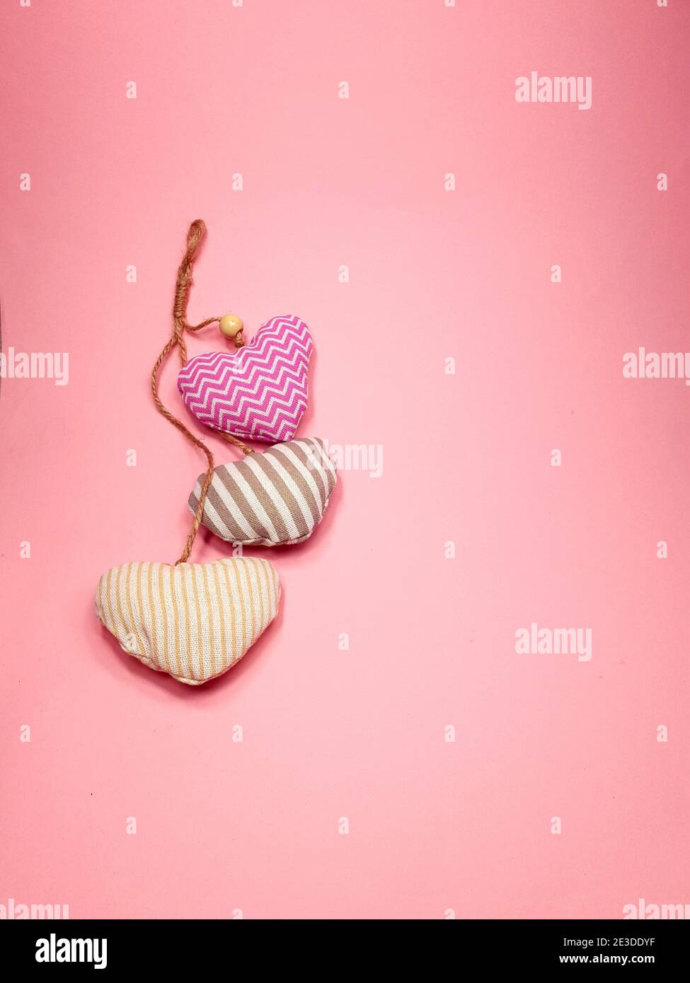i cuori di tessuto molle volano su uno sfondo rosa morbido, spazio di copia. Concetto di San Valentino per il design. Foto Stock
