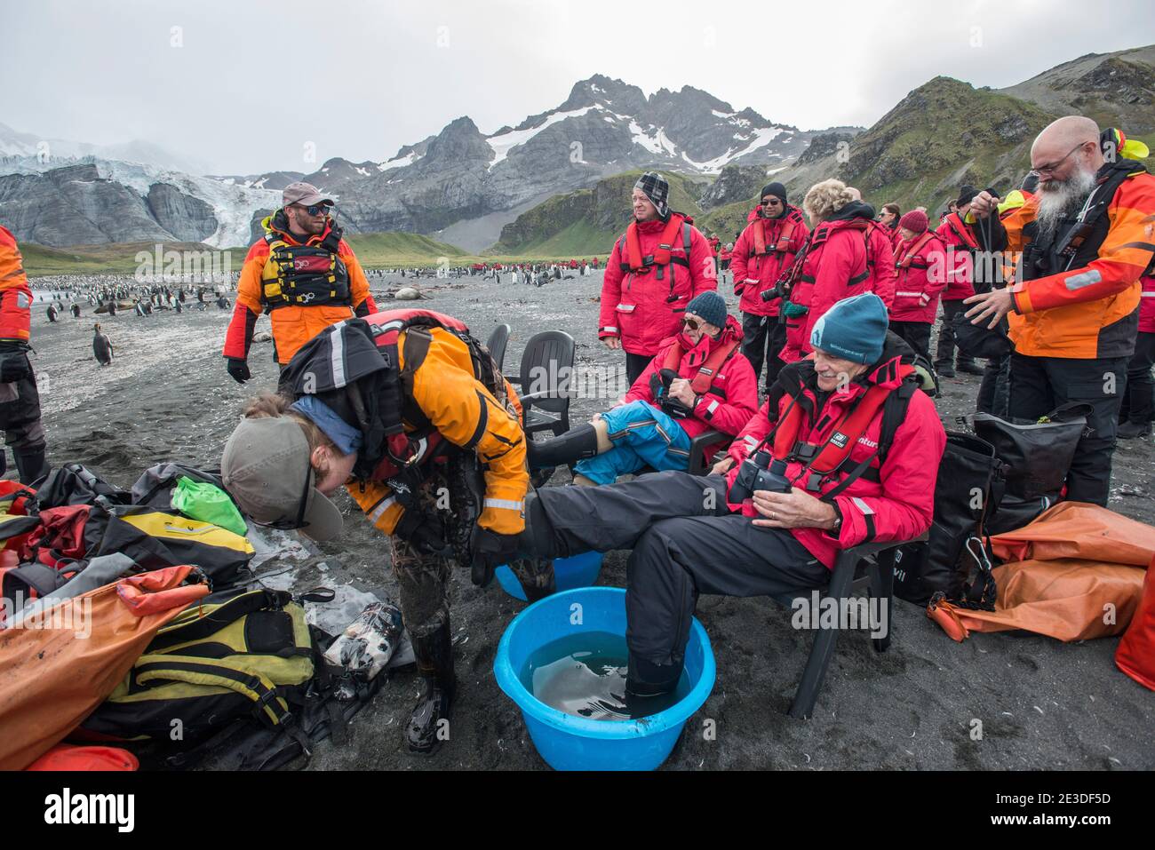 I turisti che visitano la baia del porto d'oro nell'isola di geologia meridionale Antartide puliscono gli stivali prima di lasciare la terra. Parte delle misure di biosicurezza Foto Stock