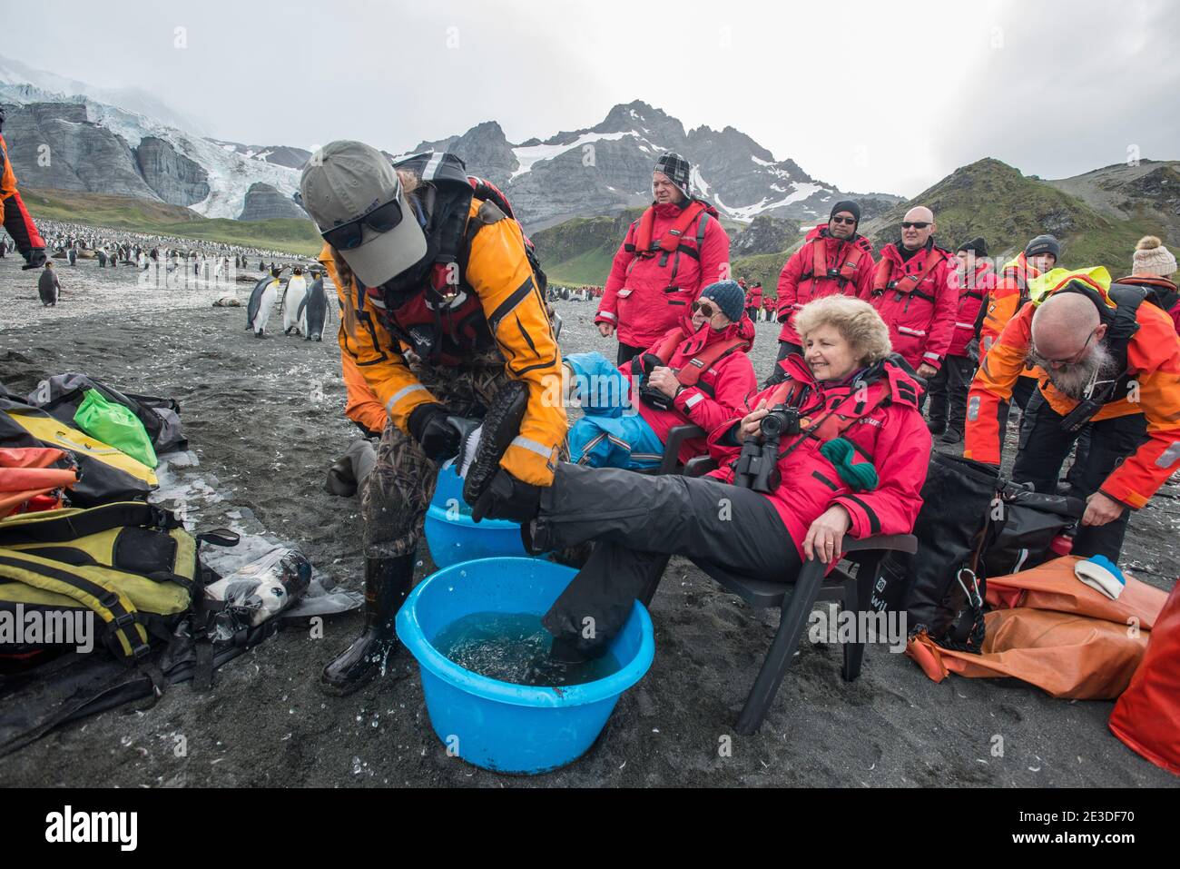 I turisti che visitano la baia del porto d'oro nell'isola di geologia meridionale Antartide puliscono gli stivali prima di lasciare la terra. Parte delle misure di biosicurezza Foto Stock
