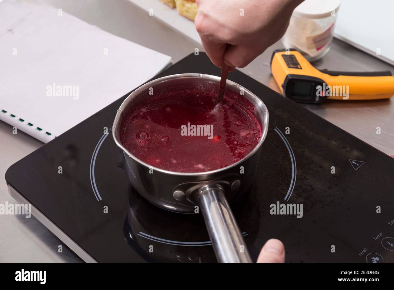 Il processo di fabbricazione della gelatina di frutta su un fornello ad induzione. Primo piano. Foto Stock