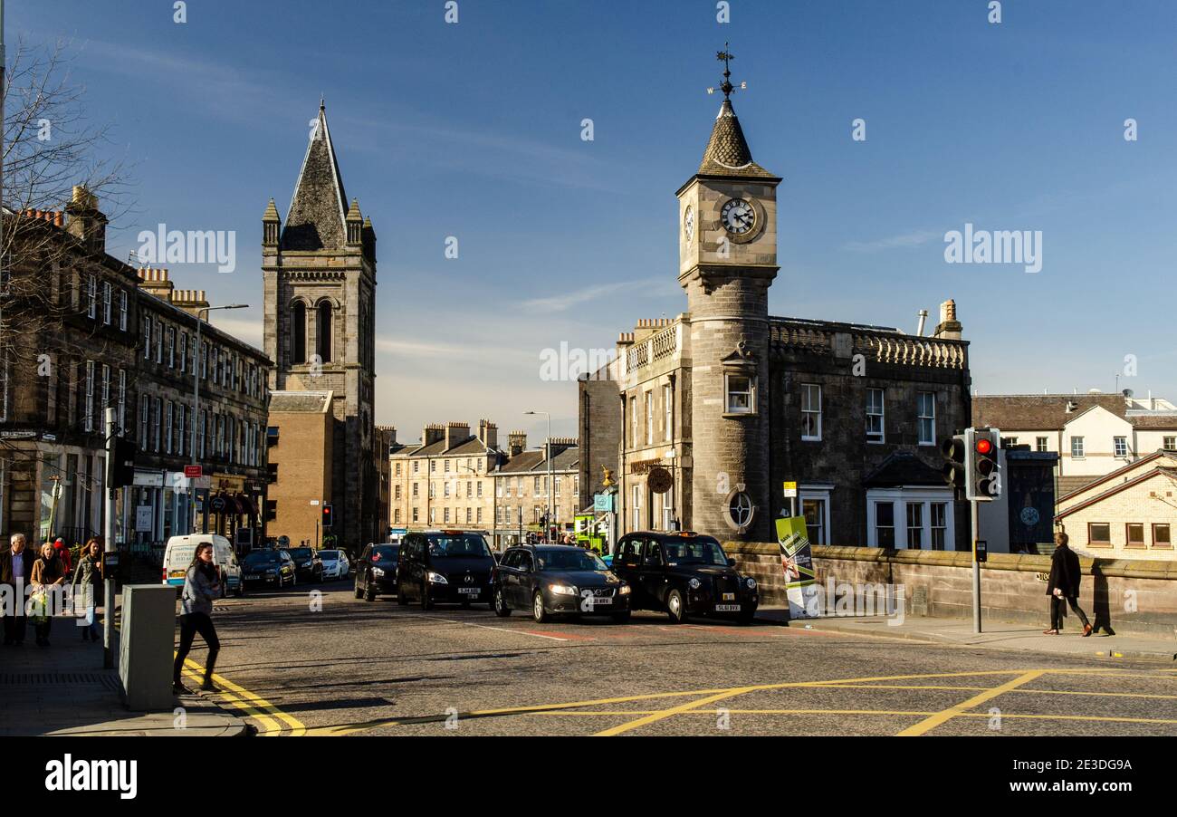Il sole splende sui tradizionali edifici di negozi, uffici e appartamenti sulla principale Deanhaugh Street nel quartiere di Edinburgo di Stockbridge. Foto Stock