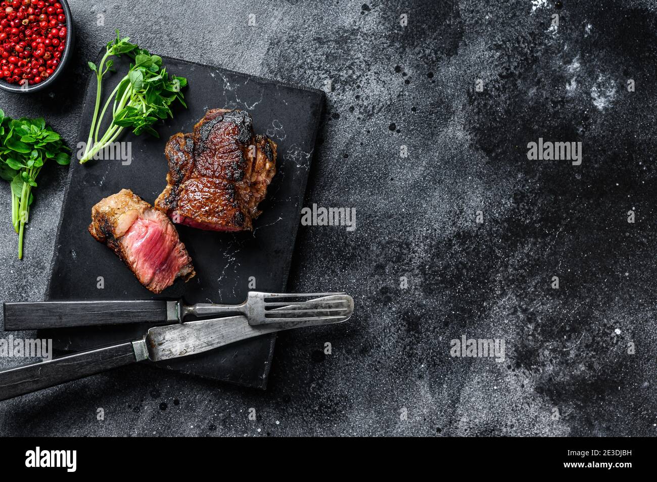 Striploin alla griglia o bistecca di New york. Sfondo nero. Vista dall'alto. Spazio di copia Foto Stock