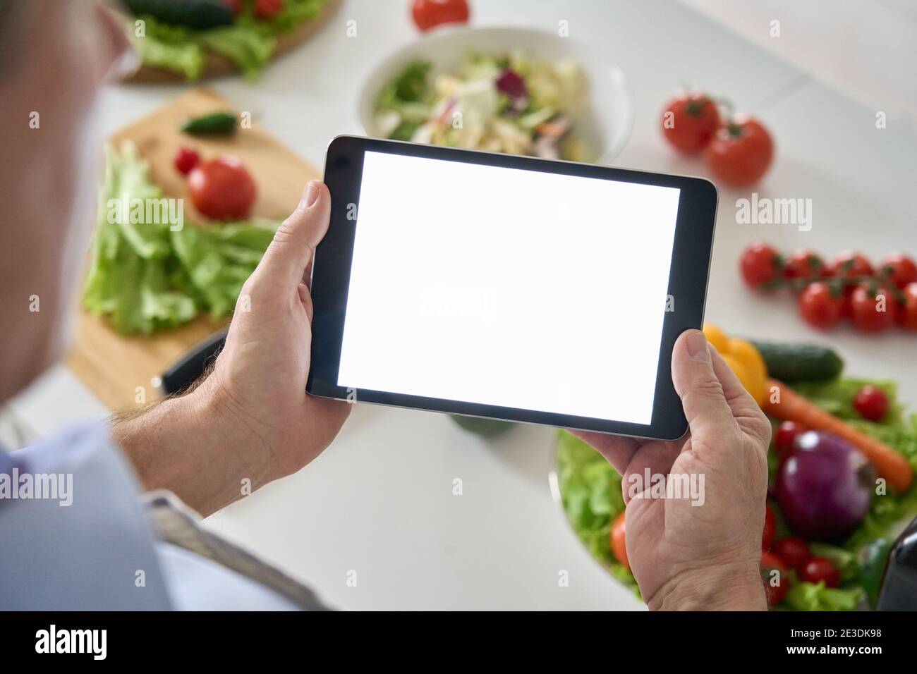 Vecchio uomo che usa la schermata di mockup del tablet. Pubblicità online per la consegna di prodotti alimentari sani Foto Stock